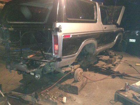 1970 Ford F-250 - This two-tone Ford Bronco is raised on blocks for maintenance, showing its rear section.