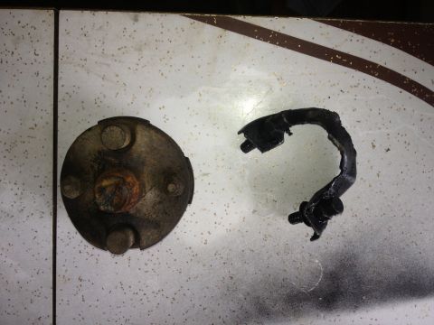 1970 Ford F-250 - A brake drum and a broken caliper bracket are shown on a tiled surface.