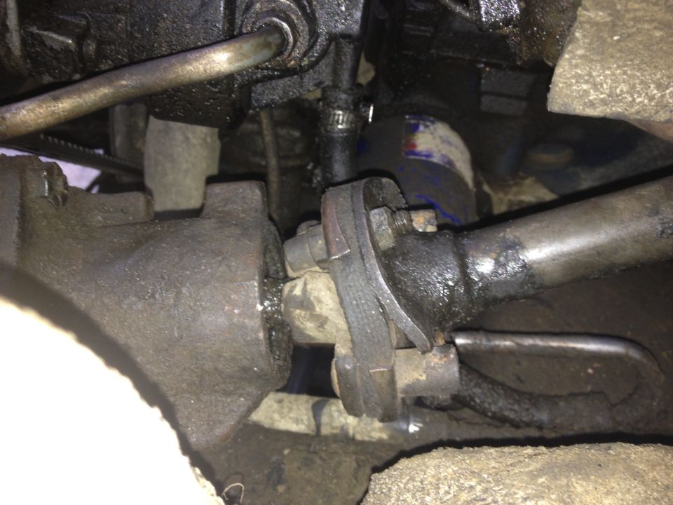 Close-up of greasy steering linkage components, possibly from a truck