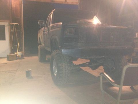 1970 Ford F-250 - This lifted pickup truck is parked inside a garage or workshop.
