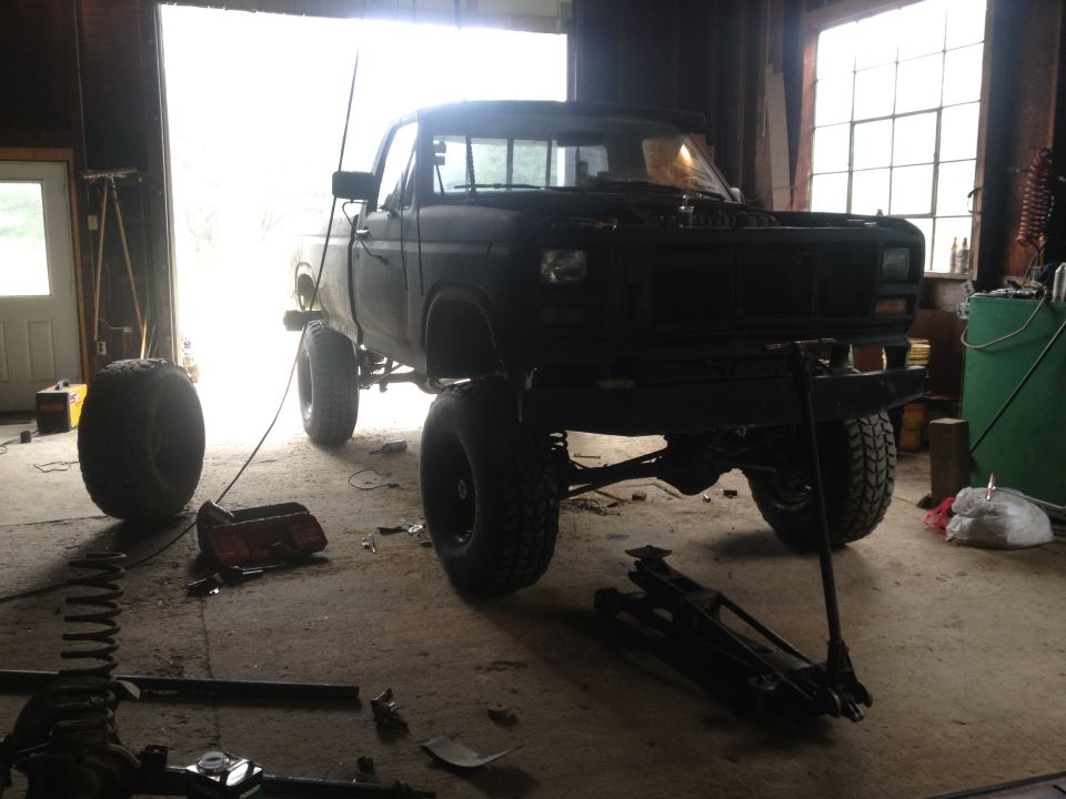 Black lifted pickup truck in garage, front view