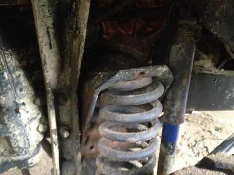 1970 Ford F-250 - Close-up of the front suspension system on a 1970 Ford F-250, showing a coil spring and shock absorber.