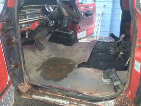 1970 Ford F-250 - The interior of a 1970 Ford F-250 shows significant wear and tear, including rust and damaged flooring.