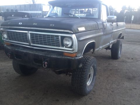 1970 Ford F-250 - This Ford pickup truck features a prominent grille and a lifted suspension with off-road tires.