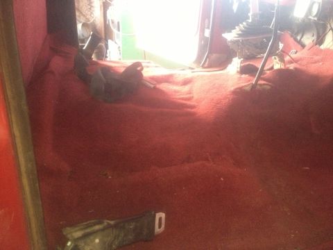 1970 Ford F-250 - The interior of a vehicle with red carpeting and a view of the gear shifter and seatbelt.