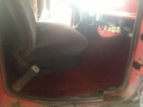 1970 Ford F-250 - Interior view of a red truck showing the driver's seat and floor.