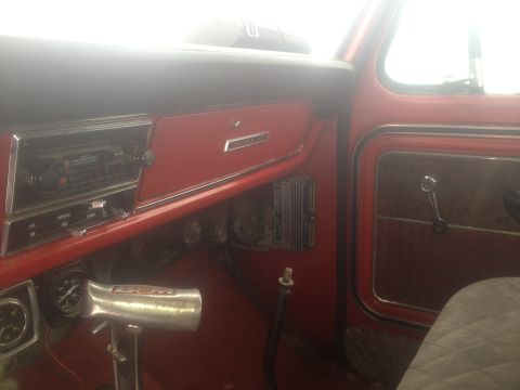 1970 Ford F-250 - The interior of a red 1970 Ford F-250 truck, with a focus on the dashboard and driver's side door.