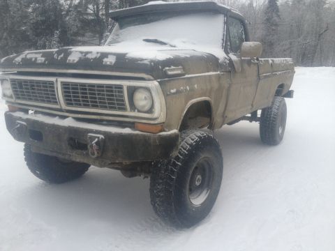 1970 Ford F-250 - This 1970 Ford F-250 pickup truck is covered in snow, showing its grille and front end.