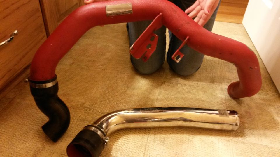 Red and chrome intake pipes with black couplers and hose clamps. A label is visible on the red pipe