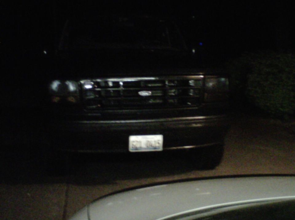 1994 Ford Bronco front grille and headlights at night