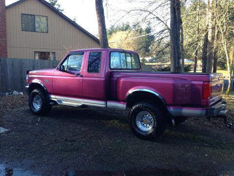 1992 Ford F-150 - This pink 1992 Ford F-150 pickup truck is parked outside a house.