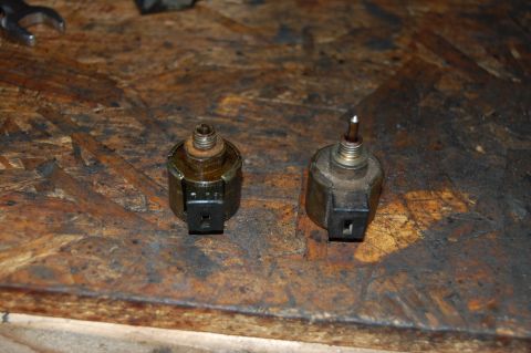 2006 Honda RANCHER - Two solenoid valves are shown on a workbench, possibly for comparison or replacement.
