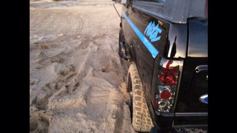 1992 Ford Bronco - Rear view of a 1992 Ford Bronco Nite edition on sandy terrain.