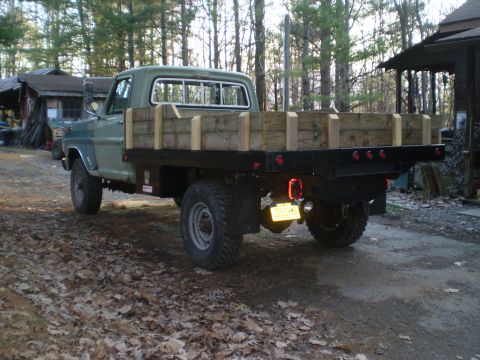 1979 Ford Bronco - Rear view of a flatbed truck with custom wooden bed sides. Likely a 1973 Ford F-Series.