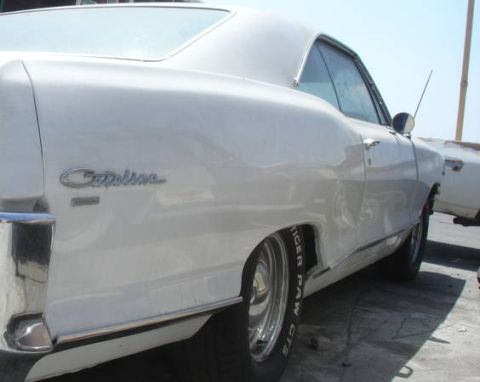 1965 Pontiac Catalina - Rear quarter view of a white 1965 Pontiac Catalina coupe with visible chrome trim and tire branding.
