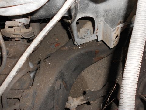 1965 Pontiac Catalina - A close-up view shows the underside of a vehicle's frame and suspension components, covered in dirt and grime.