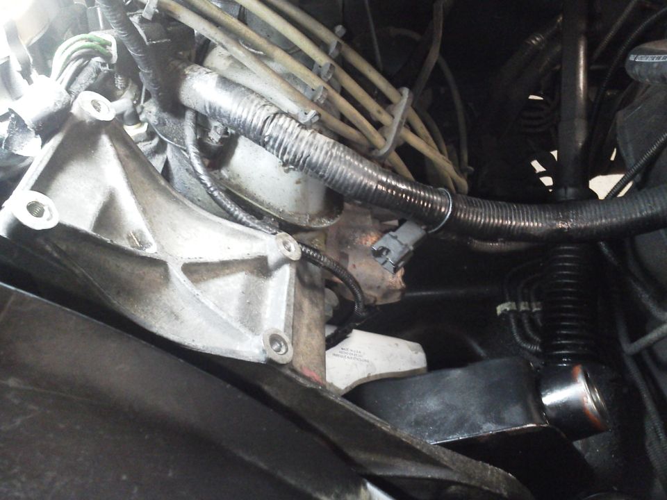 Engine bay with power steering pump bracket, hoses, and wiring loom