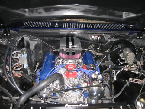 1982 Ford Bronco - The engine bay of a vehicle, a V8 engine with blue valve covers and a chrome air cleaner assembly.