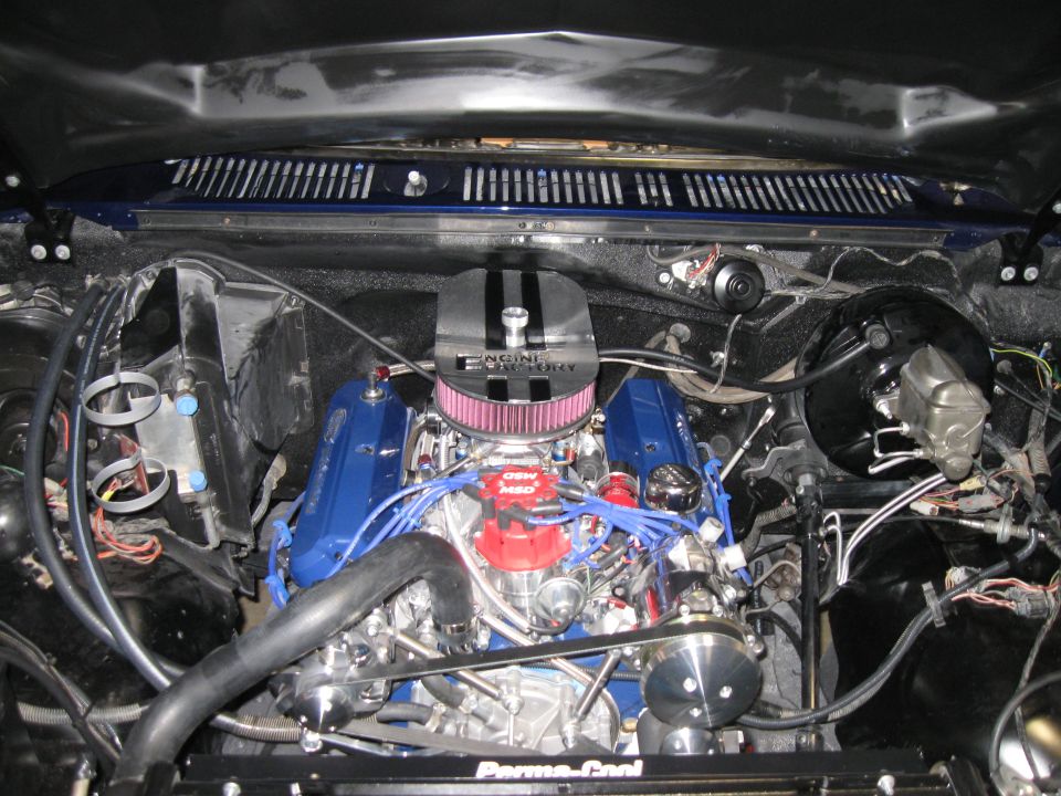 Engine bay with V8 engine, blue valve covers, and chrome air cleaner