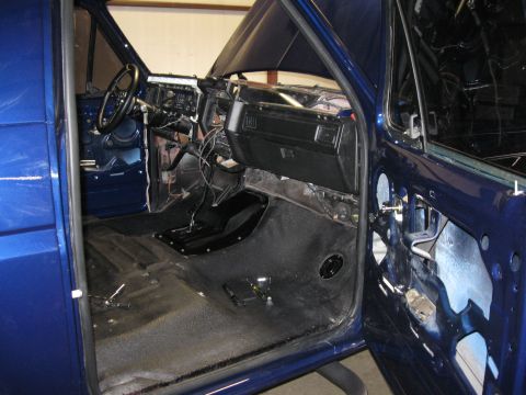 1982 Ford Bronco - The interior of a blue truck is shown with the doors open and parts of the dashboard removed for repair.