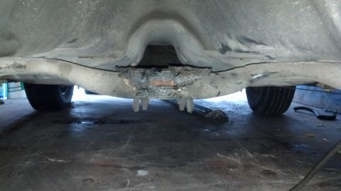 1985 Mercury Grand Marquis - The underside of a vehicle shows its frame and suspension, with tires visible in the background.