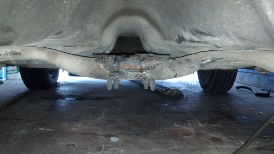 Underside view of a car's frame and suspension components, with tires visible