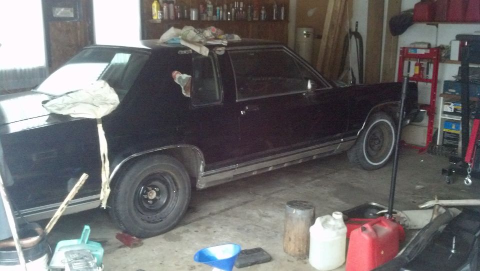 Black 1985 Mercury Grand Marquis coupe in a garage