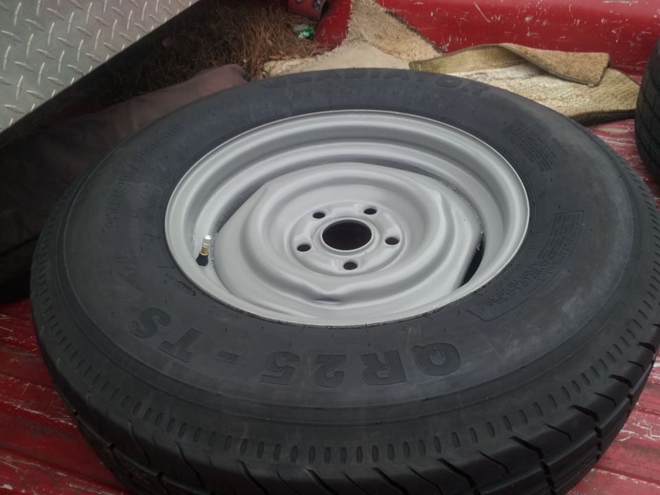 Spare tire on a silver rim, with text QR25-TS visible on the tire sidewall