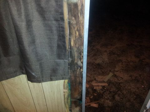 1986 Ford Bronco - Damage to an interior wall shows exposed framing and insulation, with debris scattered on the floor.