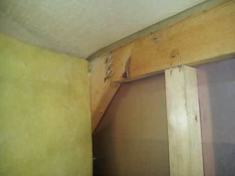 1986 Ford Bronco - Close-up view of unfinished interior construction with visible wood framing and insulation material.