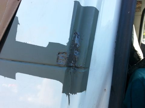 1992 Ford Bronco - The photo shows a close-up of a vehicle's door hinge area, highlighting recent rust repair and painting.