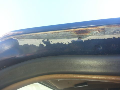 1994 Ford Bronco - The image shows corrosion and paint damage along the upper edge of a vehicle's body, indicating potential rust issues.