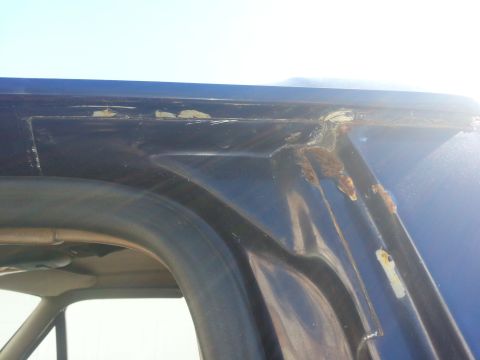 1994 Ford Bronco - Rust is visible on the rain gutter of this blue SUV, indicating potential body damage.
