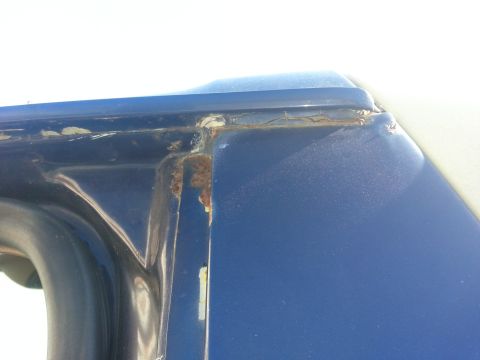 1994 Ford Bronco - Rust is visible on the door frame of a blue vehicle, indicating potential corrosion issues.