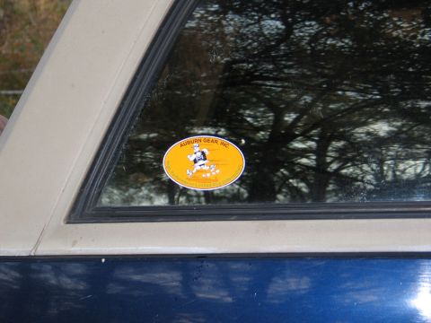1995 Ford Bronco - An oval sticker for Auburn Gear, Inc. is affixed to the window of a blue vehicle.