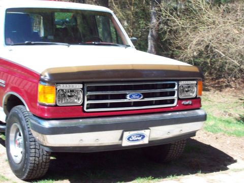 1994 Ford Bronco - This Ford Bronco features a two-tone paint job and a prominent Ford emblem on the grille.