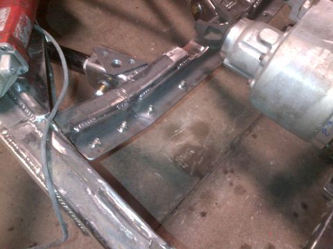 1985 Jeep CJ7 - Close-up of a custom welded bracket on a vehicle's frame during a build.