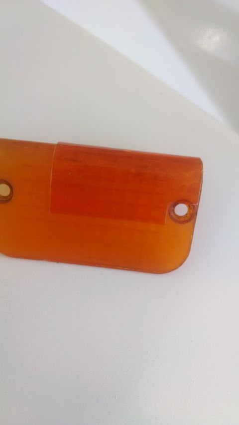1995 Ford Bronco - This orange plastic part features two mounting holes and an amber insert, likely a marker light or reflector.