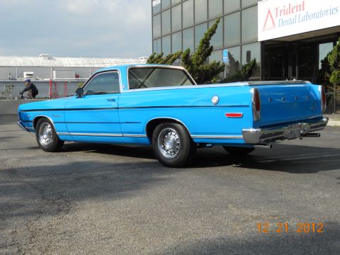 1969 Ford Ranchero - A bright blue 1969 Ford Ranchero is parked in front of a modern building.