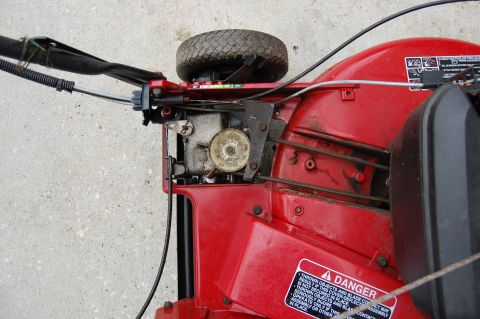 2006 Honda RANCHER - Close-up view of the engine and wheel assembly on a red lawnmower.