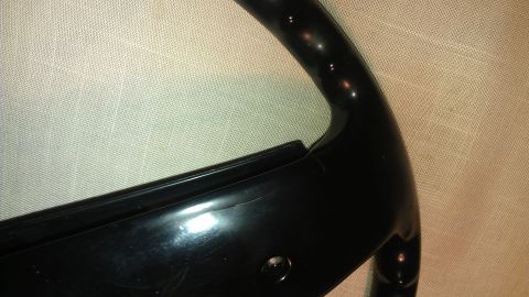 1980 Pontiac Trans Am - A close-up view of a damaged black plastic automotive trim piece.