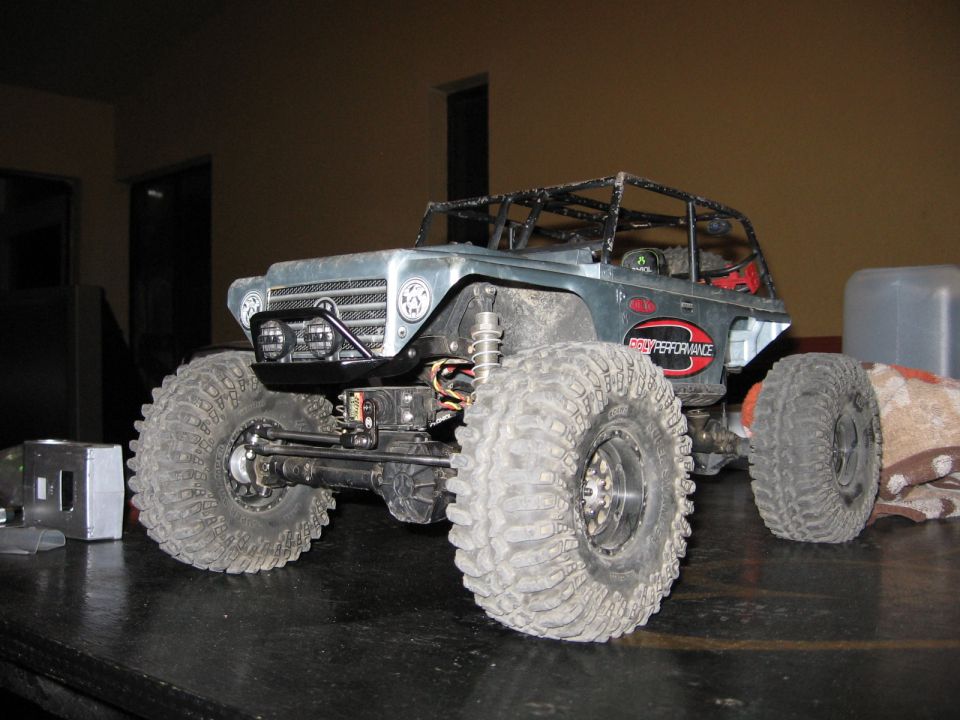 Silver remote control rock crawler with large tires and roll cage