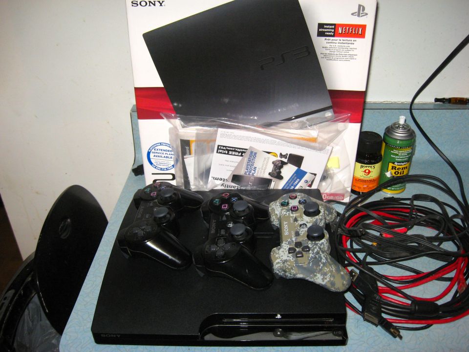 PlayStation 3 console with three controllers and cables