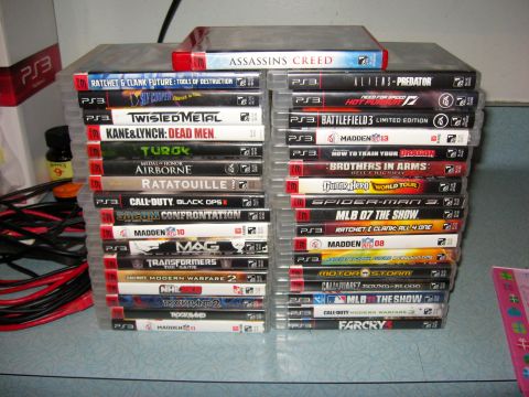 1992 Ford Mustang - A collection of PS3 video games is neatly stacked on a surface, with cables visible to the left.