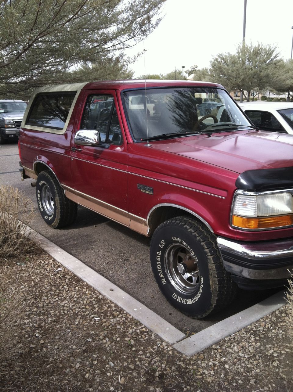 Red 1994 Ford Bronco with tan trim, parked in a lot