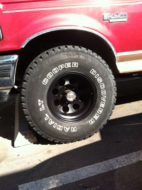 1994 Ford Bronco - Close-up of a red Ford Bronco's side, showing its tire and fender with the 'BRONCO' badge.