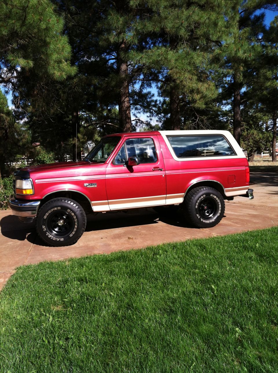 Red and white 1994 Ford Bronco parked on a driveway