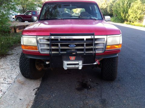 1994 Ford Bronco - This 1994 Ford Bronco features a front winch and brush guard, with another vehicle visible in the background.