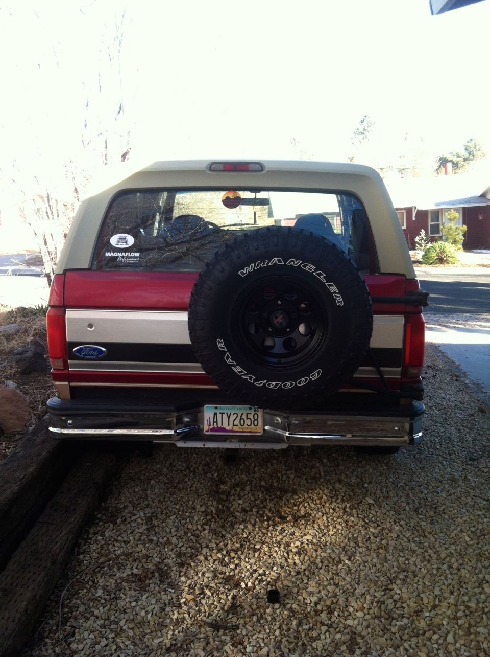 Red and tan Ford Bronco rear view with spare tire mounted on the back