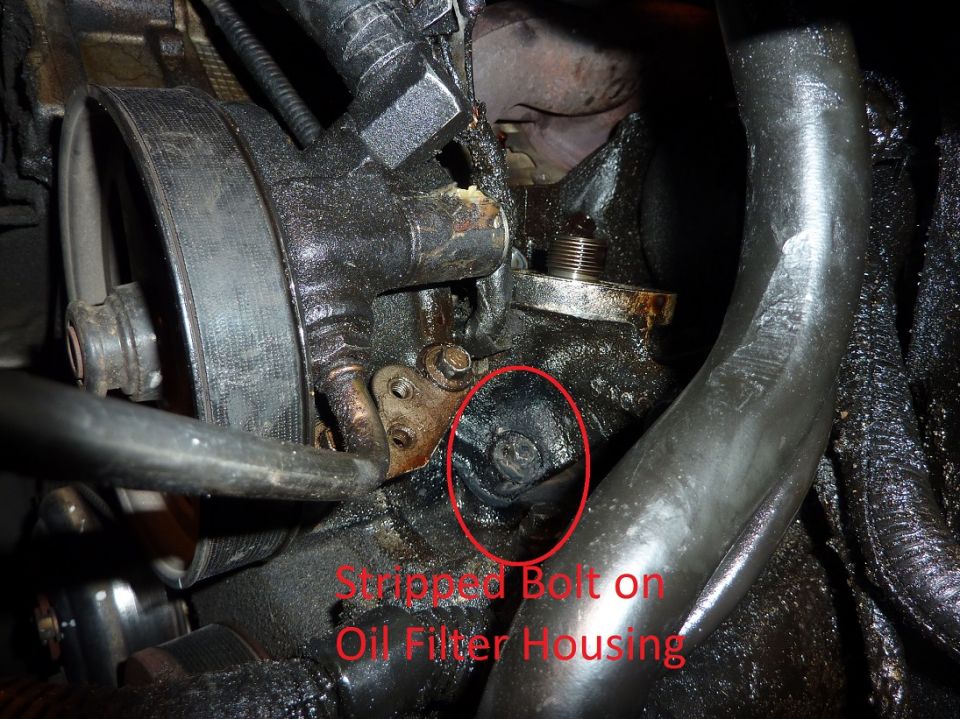 Close-up of engine component showing a stripped bolt on the oil filter housing